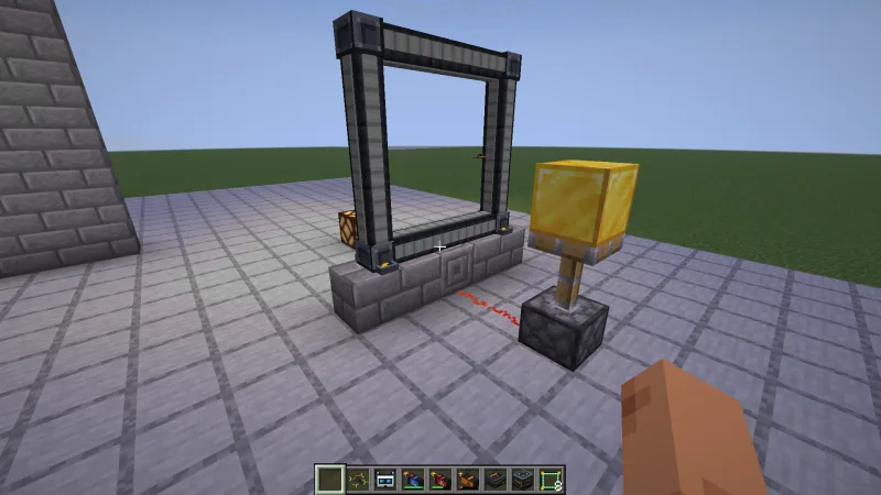 A standing gate on a row of stone bricks; redstone dust leads from the block under it to an extended piston, and a redstone lamp glows behind the gate